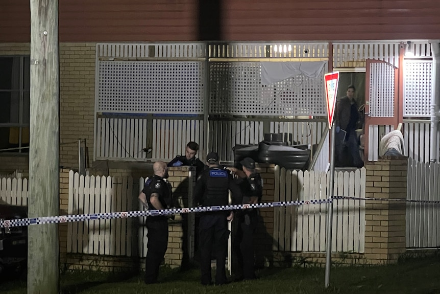Police stand at night at home where a man and woman were found dead in Albany Creek