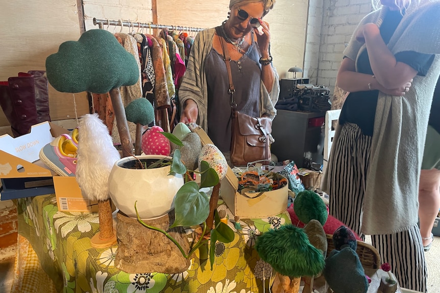 Woman shopping for handmade textiles at market