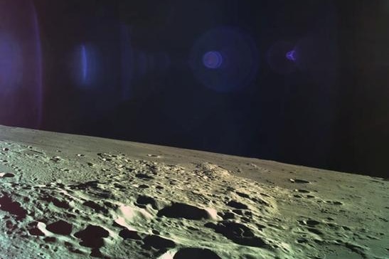 The Moon is seen with the dark blue sky above. The Moon's iconic craters are seen in the image.