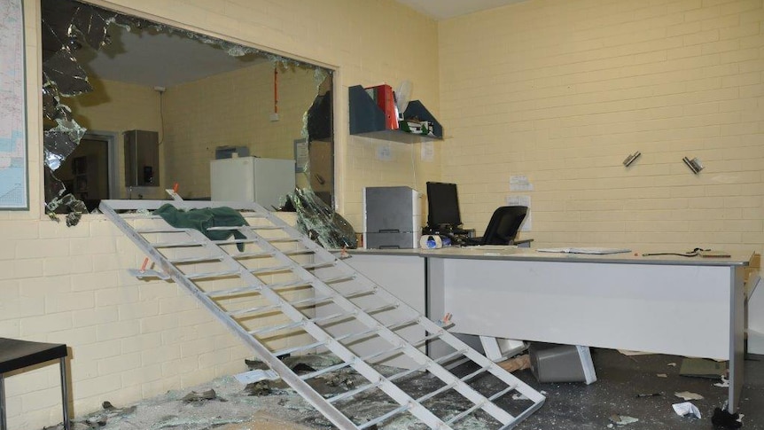 A large window smashed in a staff area of Greenough regional prison with a large metal frame lying below it.