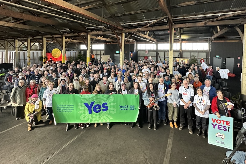 A crowd of Come Together For Yes attendees hold a big 'yes' sign in Hobart's Goods Shed