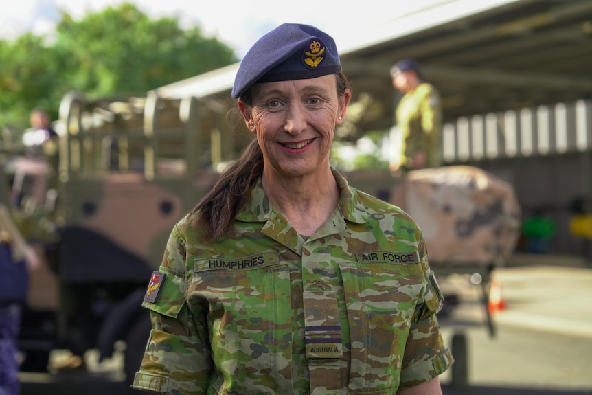 woman in blue beret wearing uniform with a brown pony tail