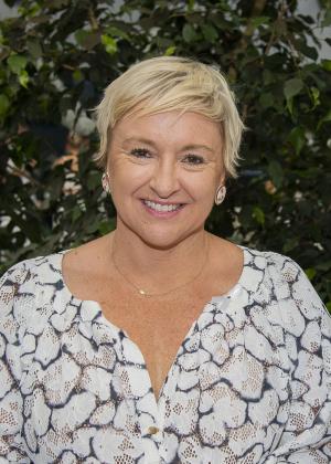 close up image of a woman with short blonde hair smiling