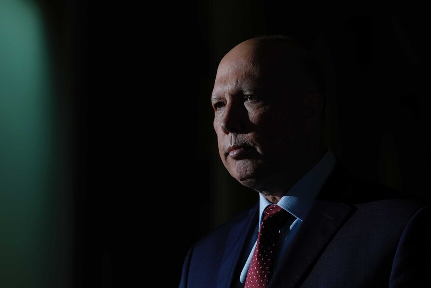 Home Affairs Minister Peter Dutton speaking to the media and looking serious