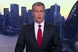 seven-network-journalist-robert-ovadia delivers the news as he looks at the camera