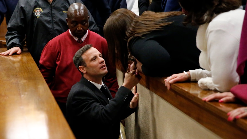 Oscar Pistorius reacts as he leaves the High Court in Pretoria