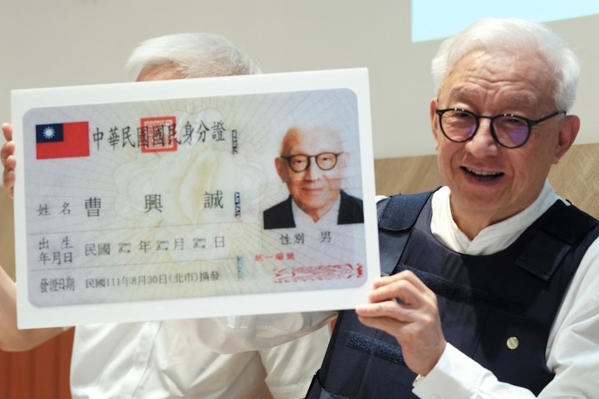 Robert Tsao affiche une copie agrandie de sa carte d'identité lors d'une conférence de presse