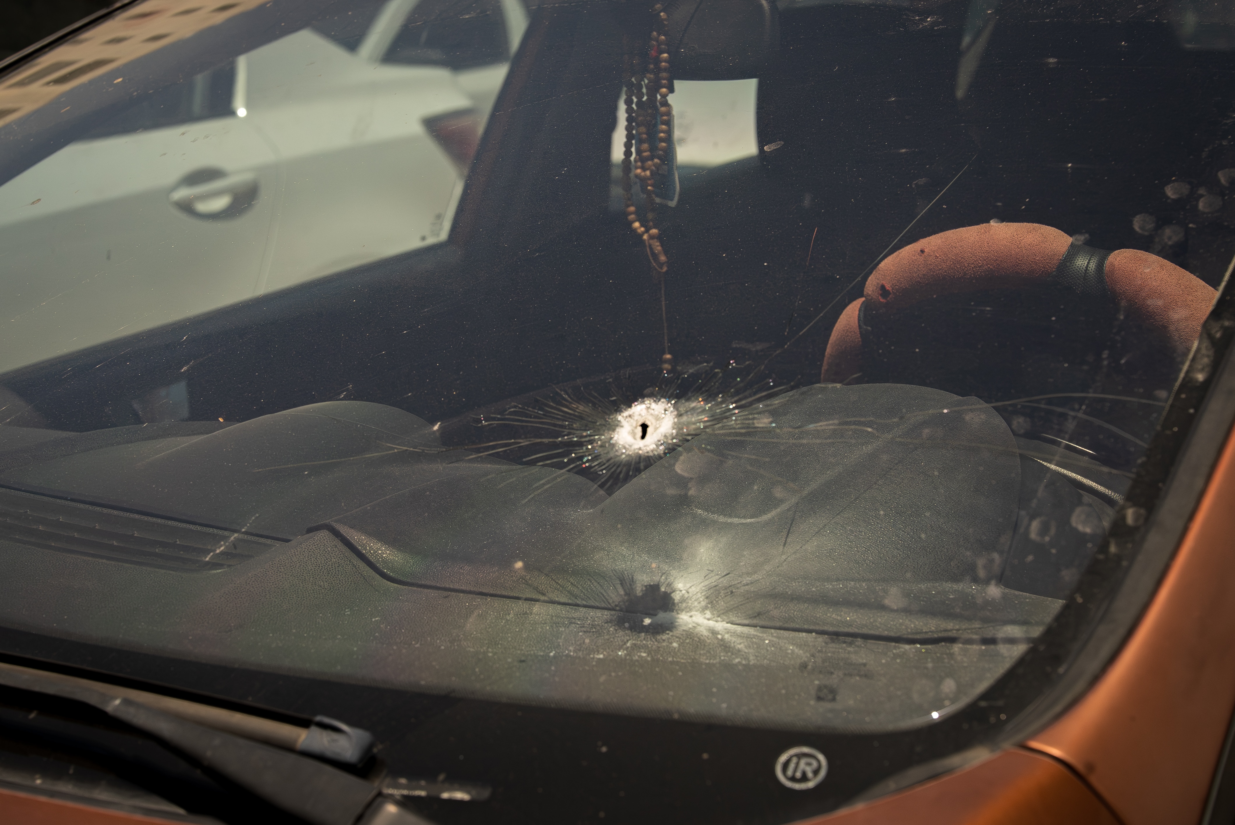A bullet hole in the windscreen of a car.