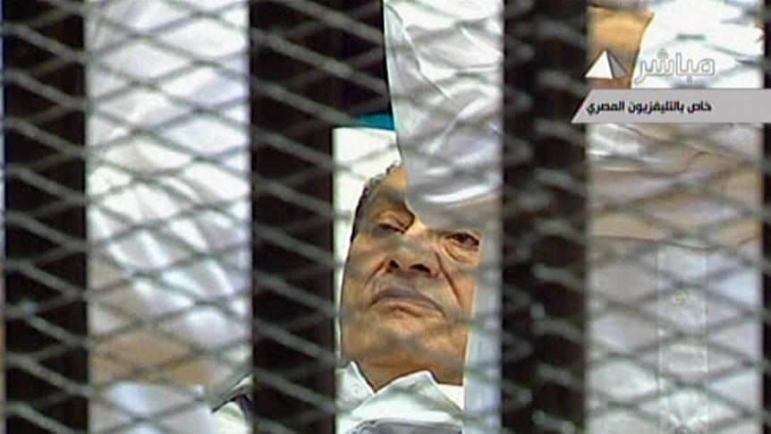 Hosni Mubarak lies on a stretcher at the opening of his trial