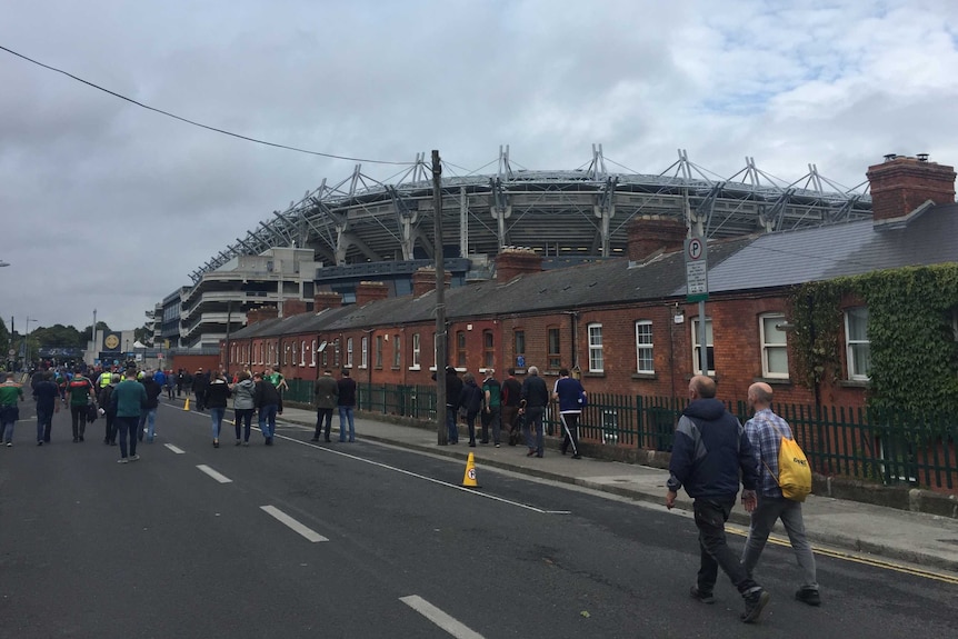 A stadium is seen looming over a row of red-brick terraced houses