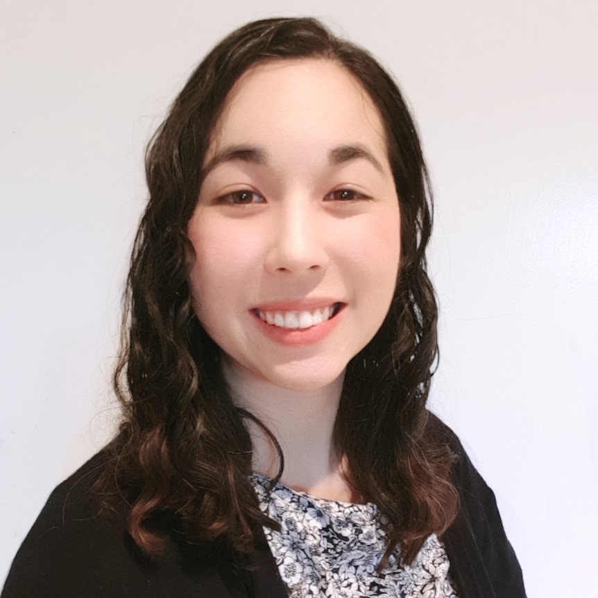 A young women in black smiling. 