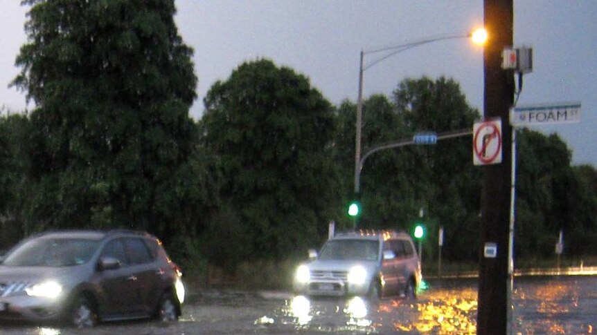 Cars drive through floodwaters in Elwood, Melbourne, around 8:00pm (AEDT) on February 5, 2011, after