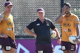 Brisbane Broncos players Brodie Croft and Anthony Milford stand on either side of assistant coach Allan Langer at training.