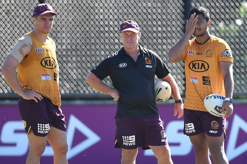 Brisbane Broncos players Brodie Croft and Anthony Milford stand on either side of assistant coach Allan Langer at training.