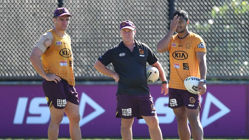 Brisbane Broncos players Brodie Croft and Anthony Milford stand on either side of assistant coach Allan Langer at training.