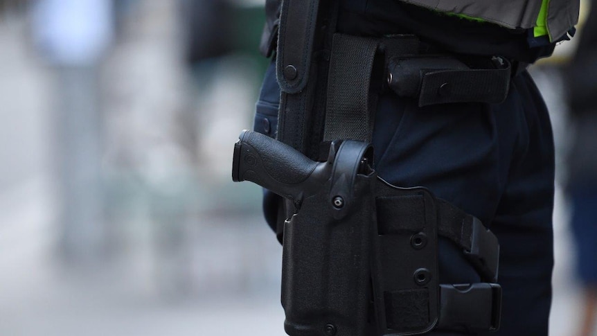 A police officer is seen carrying a gun holster