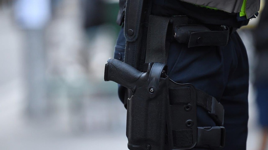 A Victorian Police officer is seen carrying a gun holster