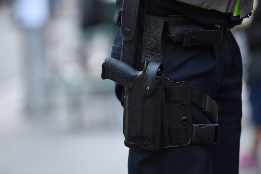 A Victorian Police officer is seen carrying a gun holster