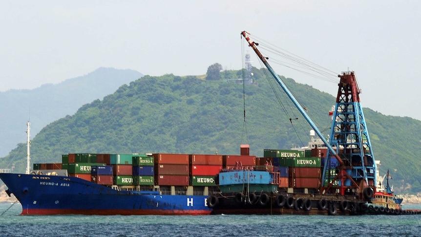 A cargo ship's containers are unloaded in Hong Kong on June 29, 2013.