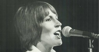 Helen Reddy sings into a microphone