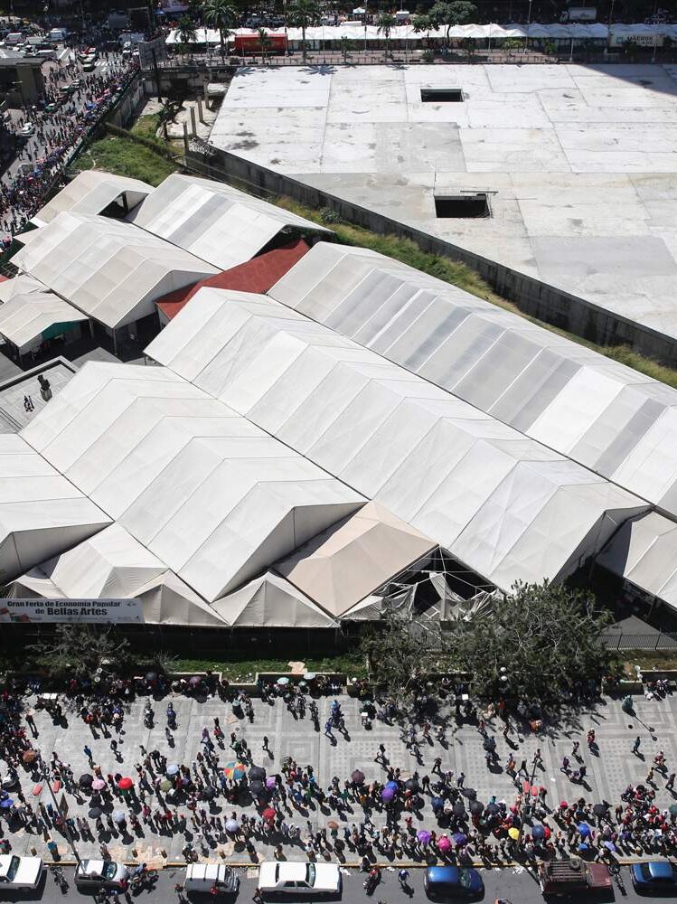 People queue at state-run street market in Caracas