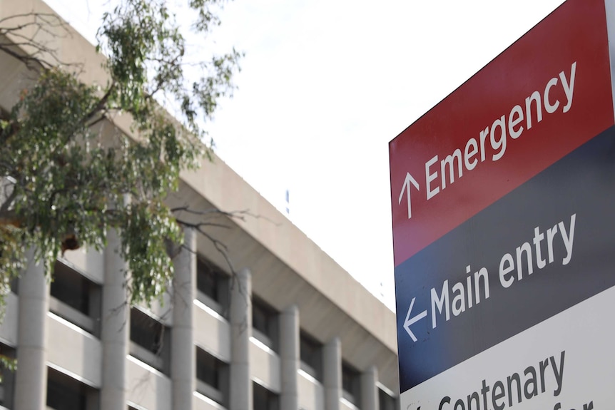 A close up of a sign pointing to the emergency department and main entry of a hospital.