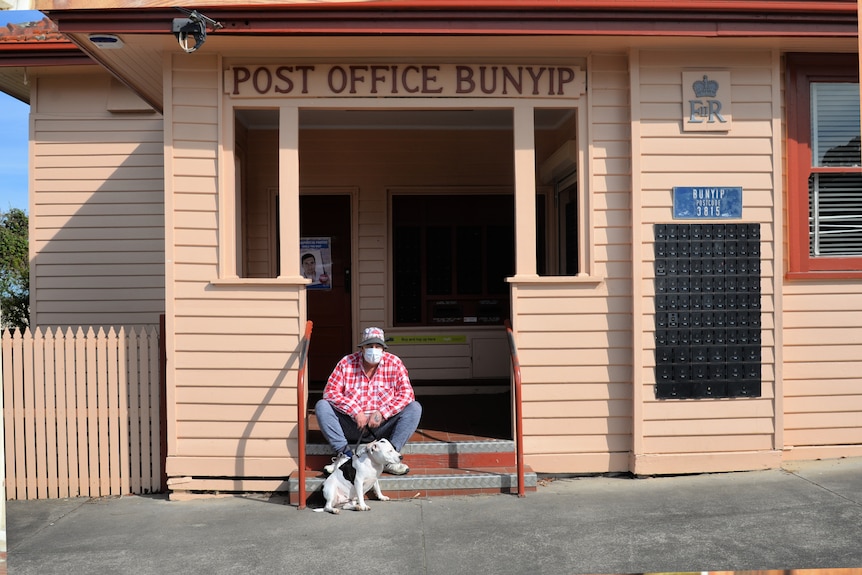 Ray Matthews sits with dog Ruby outside Bunyip post office.