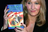 JK Rowling holding a copy of Harry Potter and the Half Blood Prince