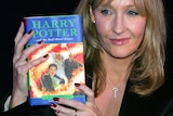 JK Rowling holding a copy of Harry Potter and the Half Blood Prince