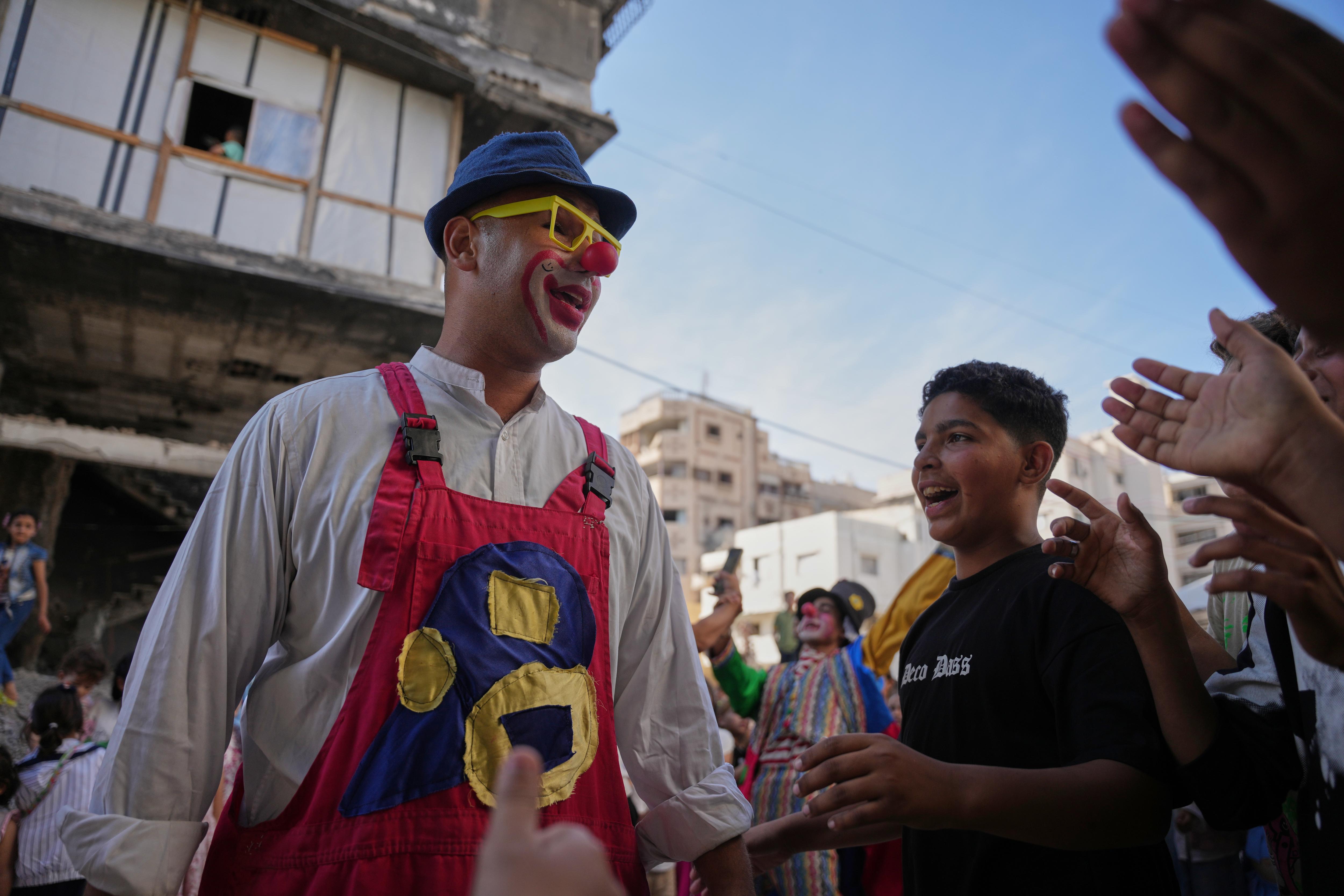A clown meets clapping children. 