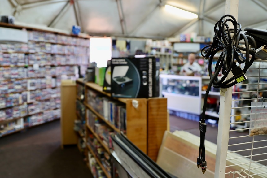 Behind the counter in a video store.