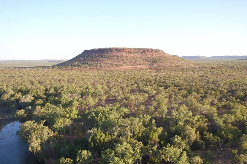 a hill in scrub with a billabong.