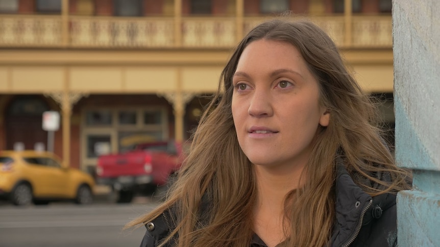 A woman in a heavy jacket looks slightly off-camera.