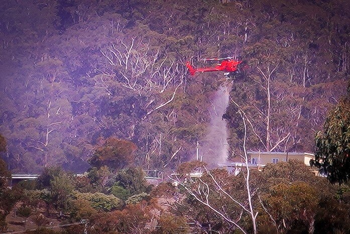 Helicopter drops water on homes.