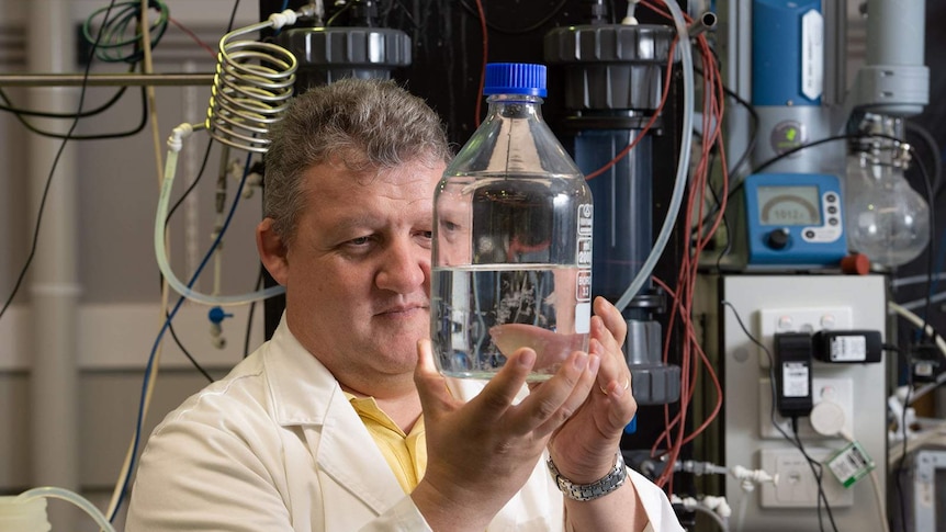 QUT scientist Graeme Millar holds a vial of water