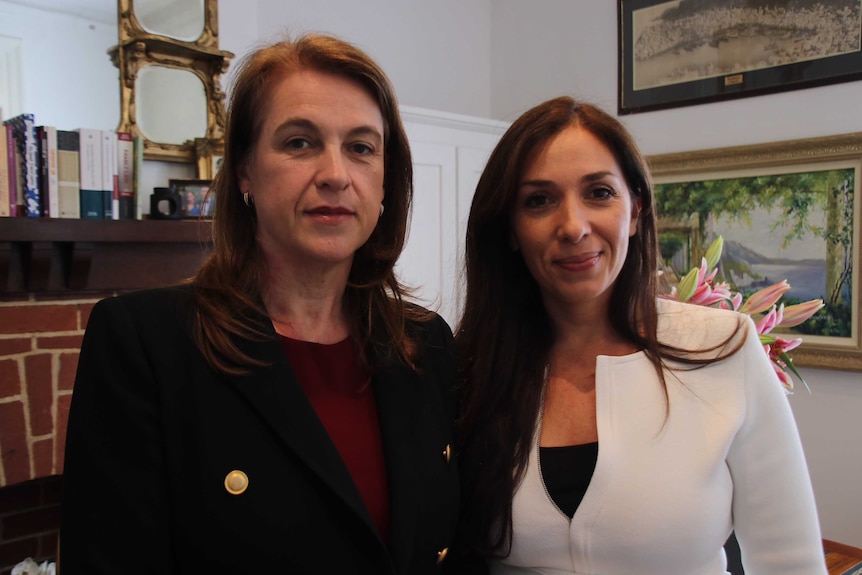 Two women pose in office