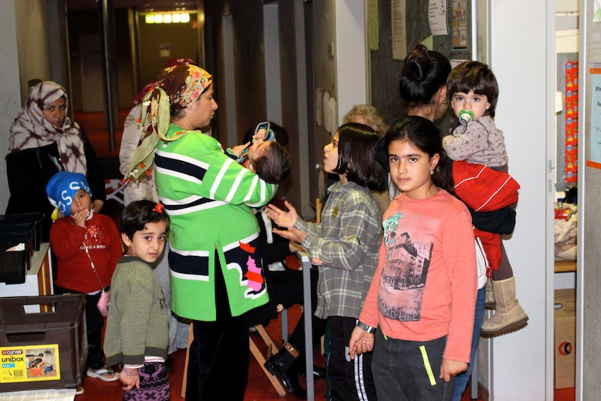 Syrian asylum seekers await immunisation at Berlin processing centre