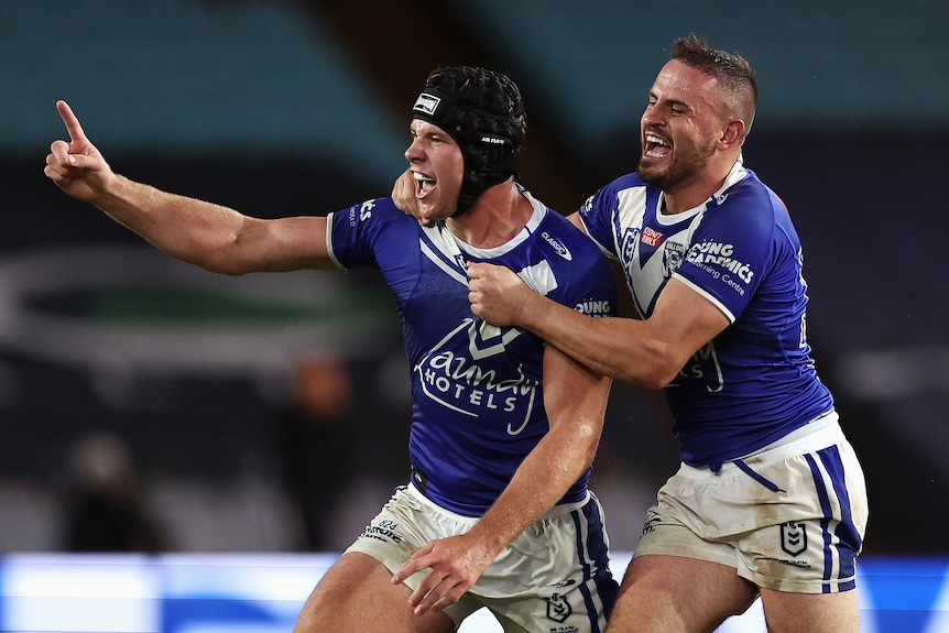 Two rugby league players celebrate after kicking a field goal