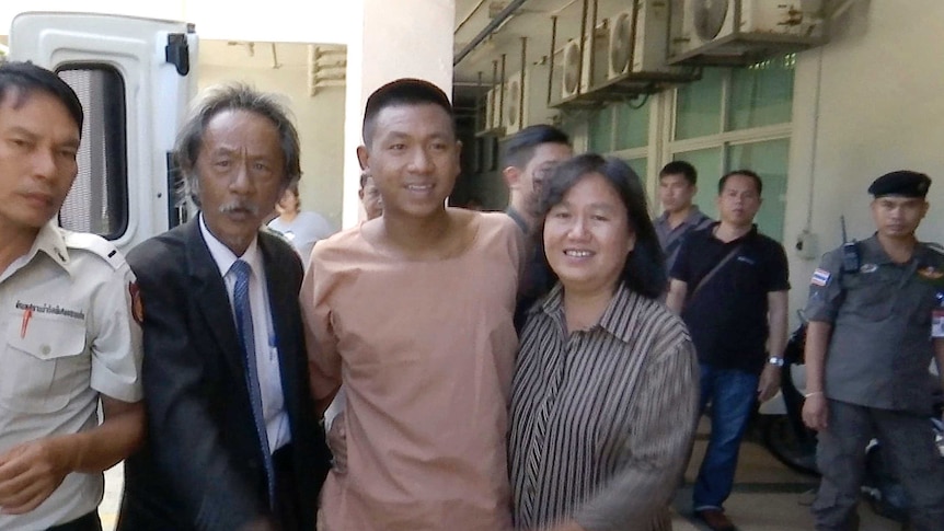 Jatupat "Pai Dao Din" Boonpattararaksa poses for a photo with his mother and father at a courthouse northeast of Bangkok.