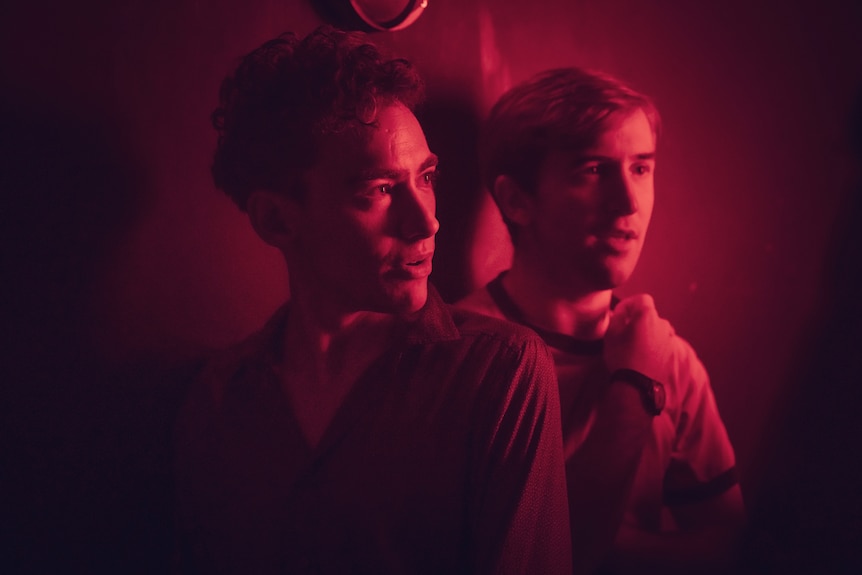 A still from the miniseries It's a Sin of two young men bathed in red light