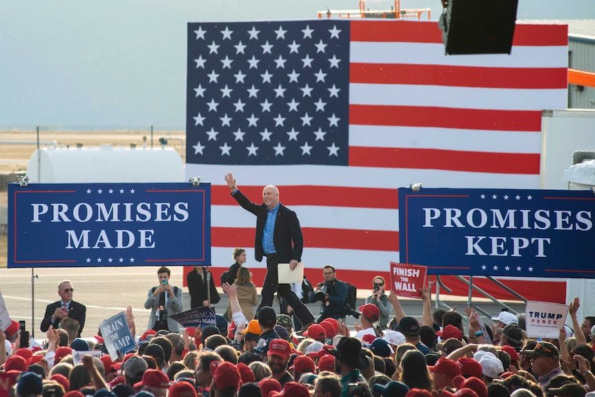 Montana Rep. Greg Gianforte walks onto the stage at an Aviation Hangar in Montana during a campaign rally.