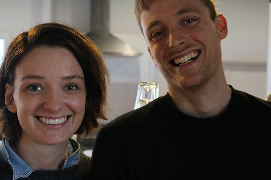 Two people standing side by side in a cafe.