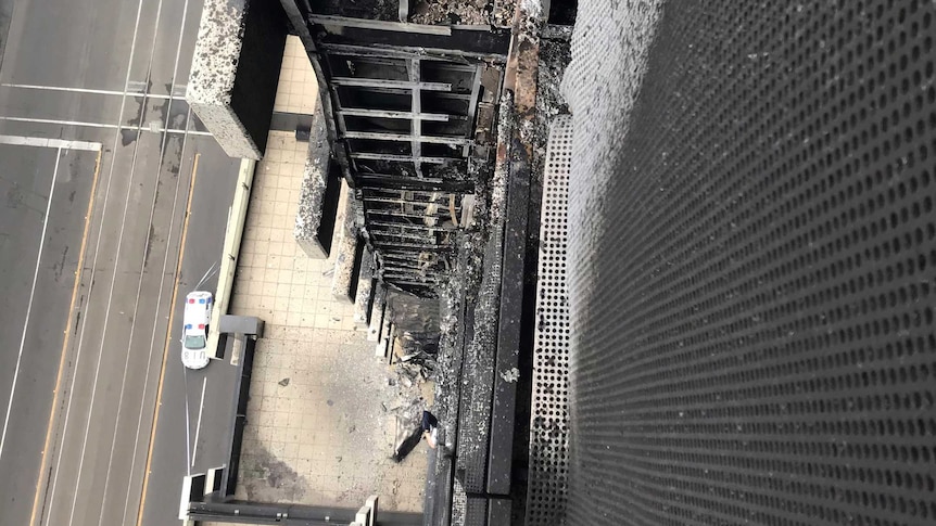 Looking down the side of a Melbourne apartment building damaged by fire.