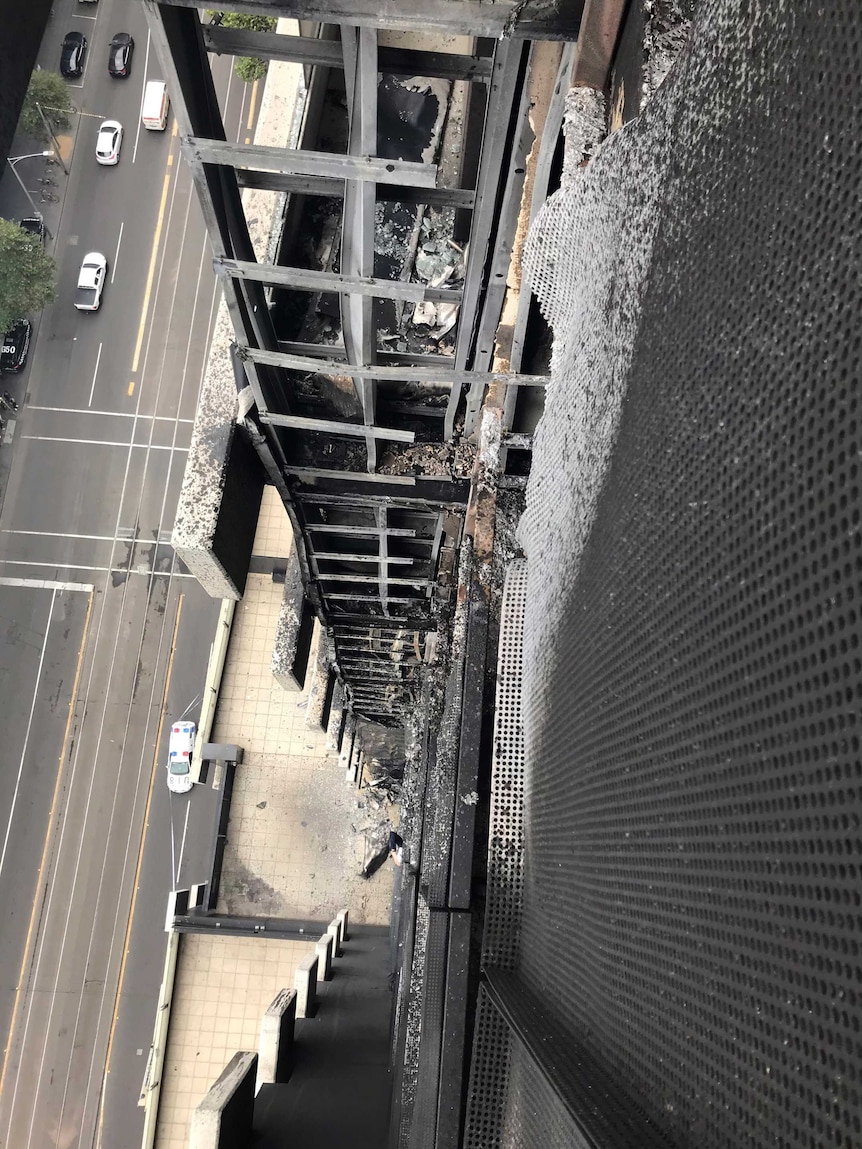 The side of a building is blackened and damaged by fire.