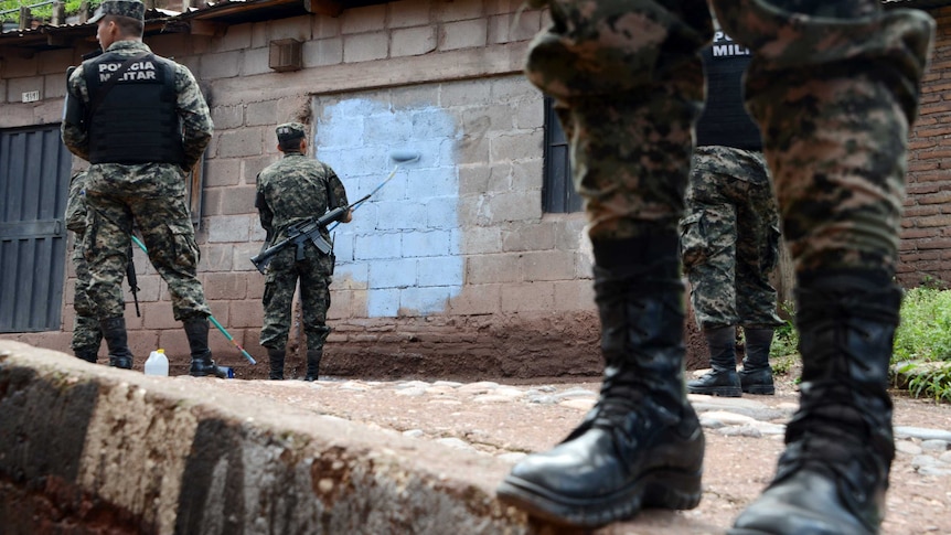 Honduras soldiers cover Mara 18 gang graffitis