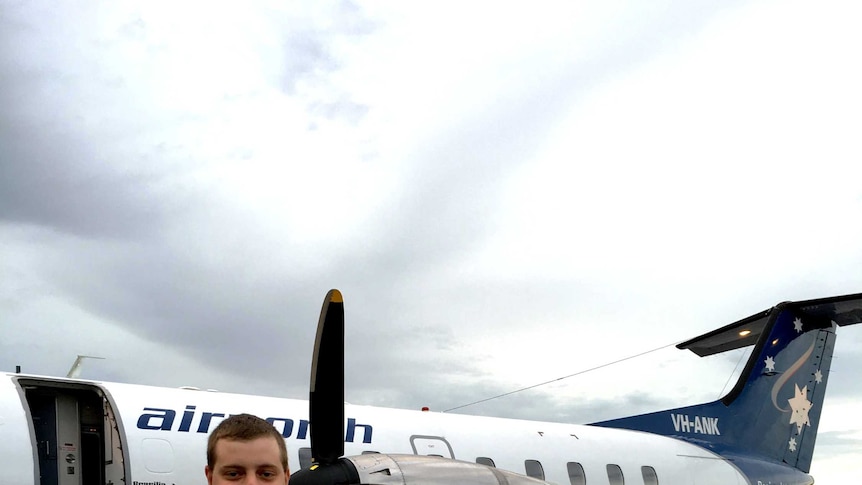 A man in front of an Embraer Brasilia aircraft