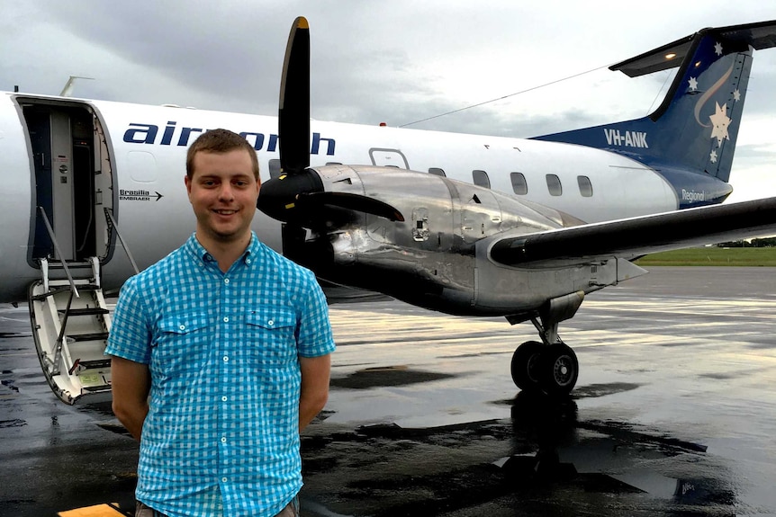 A man in front of an Embraer Brasilia aircraft