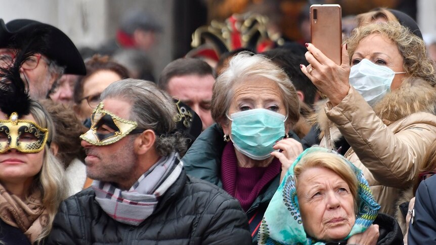 People wearing protective face masks at the Venice Carnival due to coronavirus outbreak.