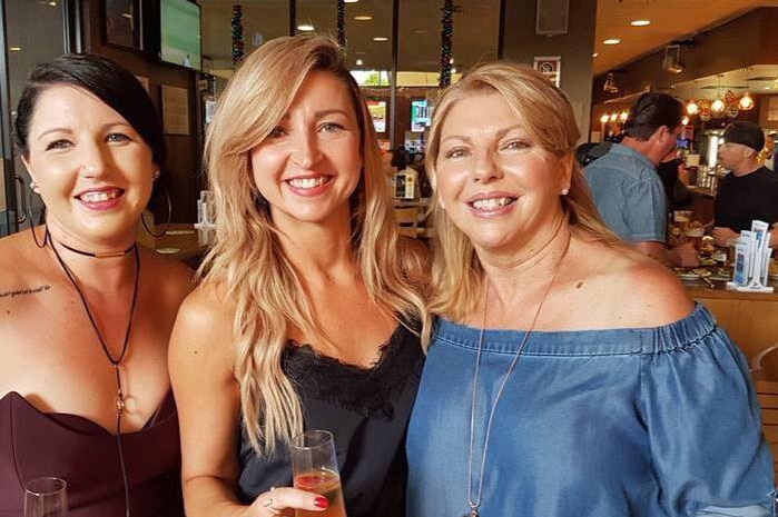 Three women smiling together.