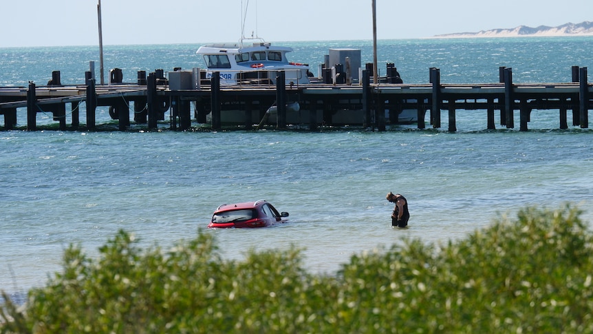 A car submerged in the ocean with just the roof showing